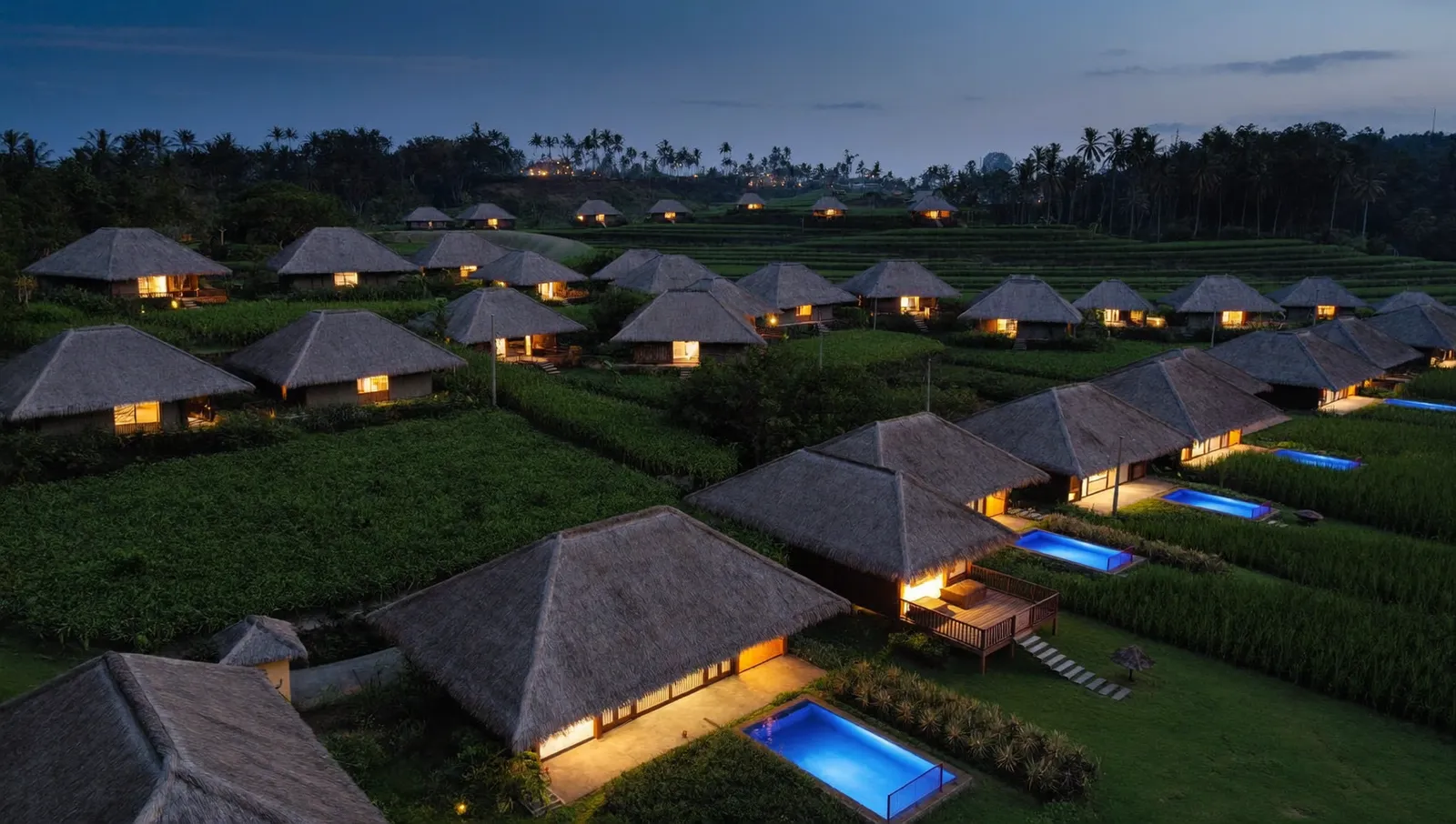 Aerial view of Bali villas glowing with warm lights at dusk — homes that keep power during blackouts